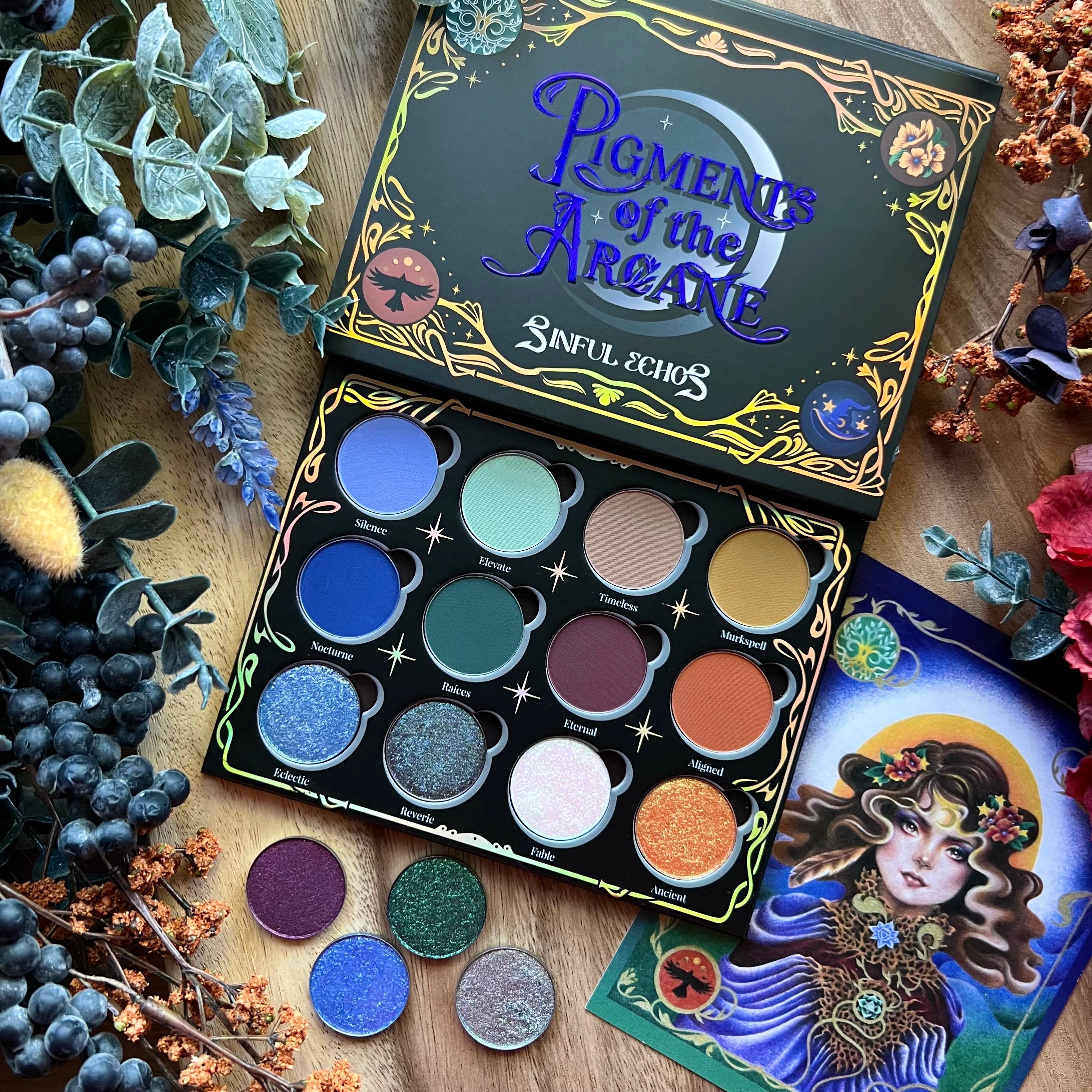 Makeup palette with 'Pigments of the Arcade' packaging on a decorative background with flowers and leaves.