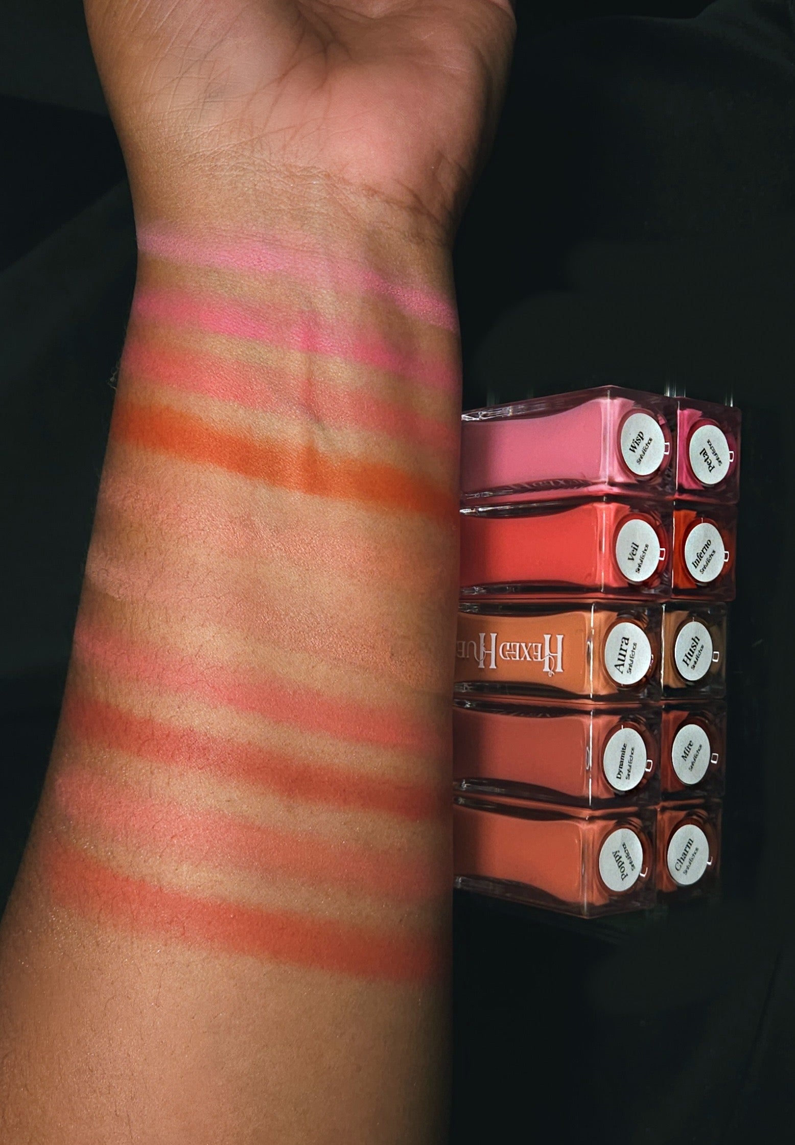 Blush arm swatches, showing the different colors, on a dark background